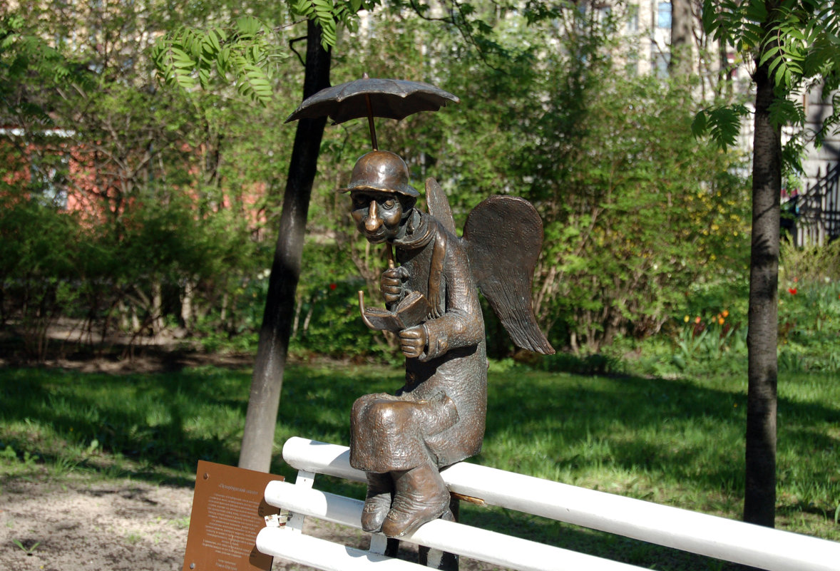 памятник читающий ангел под зонтиком на скамейке