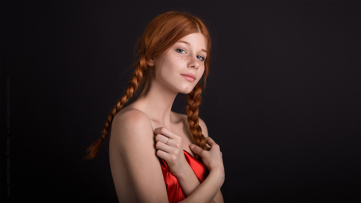 Молодая рыжая девушка позирует голая