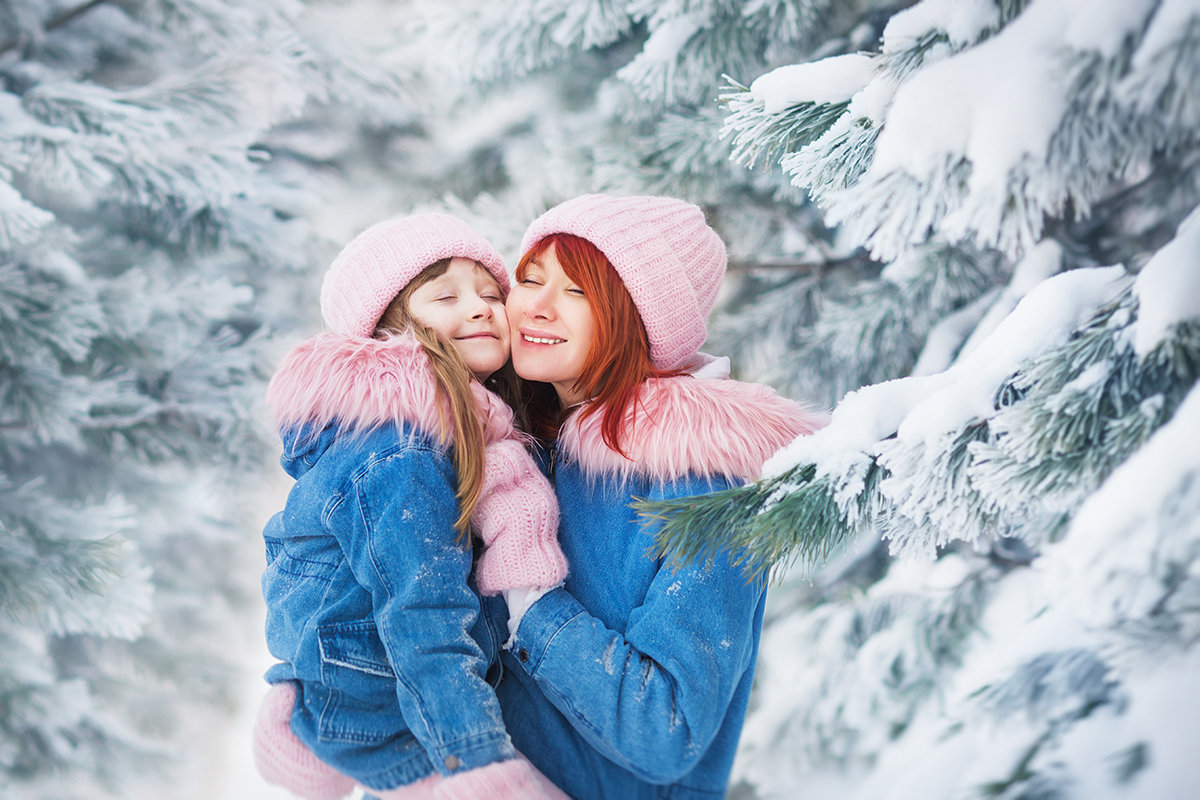 Мама с дочкой в одинаковых куртках обнимаются в лесу зимой - Кристина Киблер
