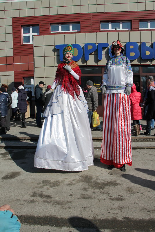 На масленице ряженые на ходулях - Олег Афанасьевич Сергеев