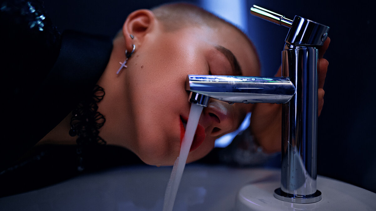 Девушка с короткой стрижкой пьет воду из-под крана в туалете одного из клубов Уфы - Lenar Abdrakhmanov