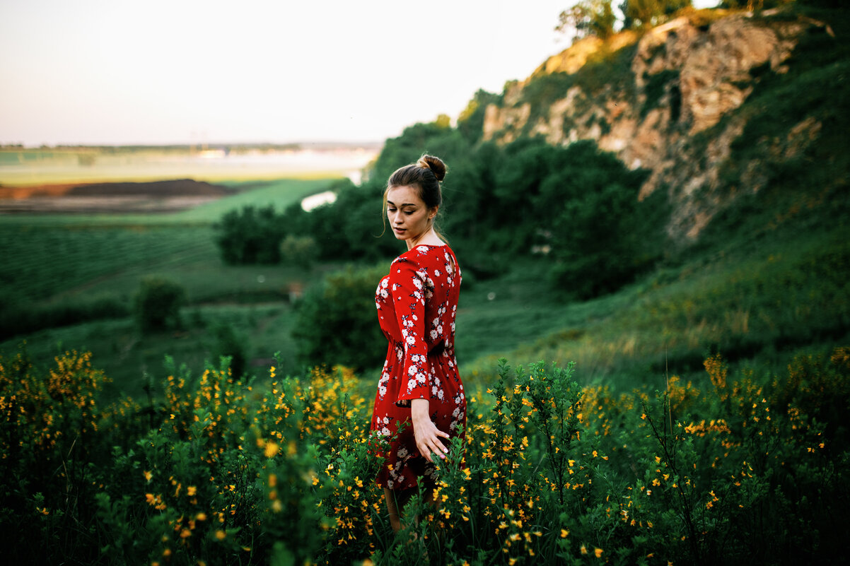 Девушка в красном платье спускается по полю с желтыми цветами на склоне горы во время рассвета - Lenar Abdrakhmanov
