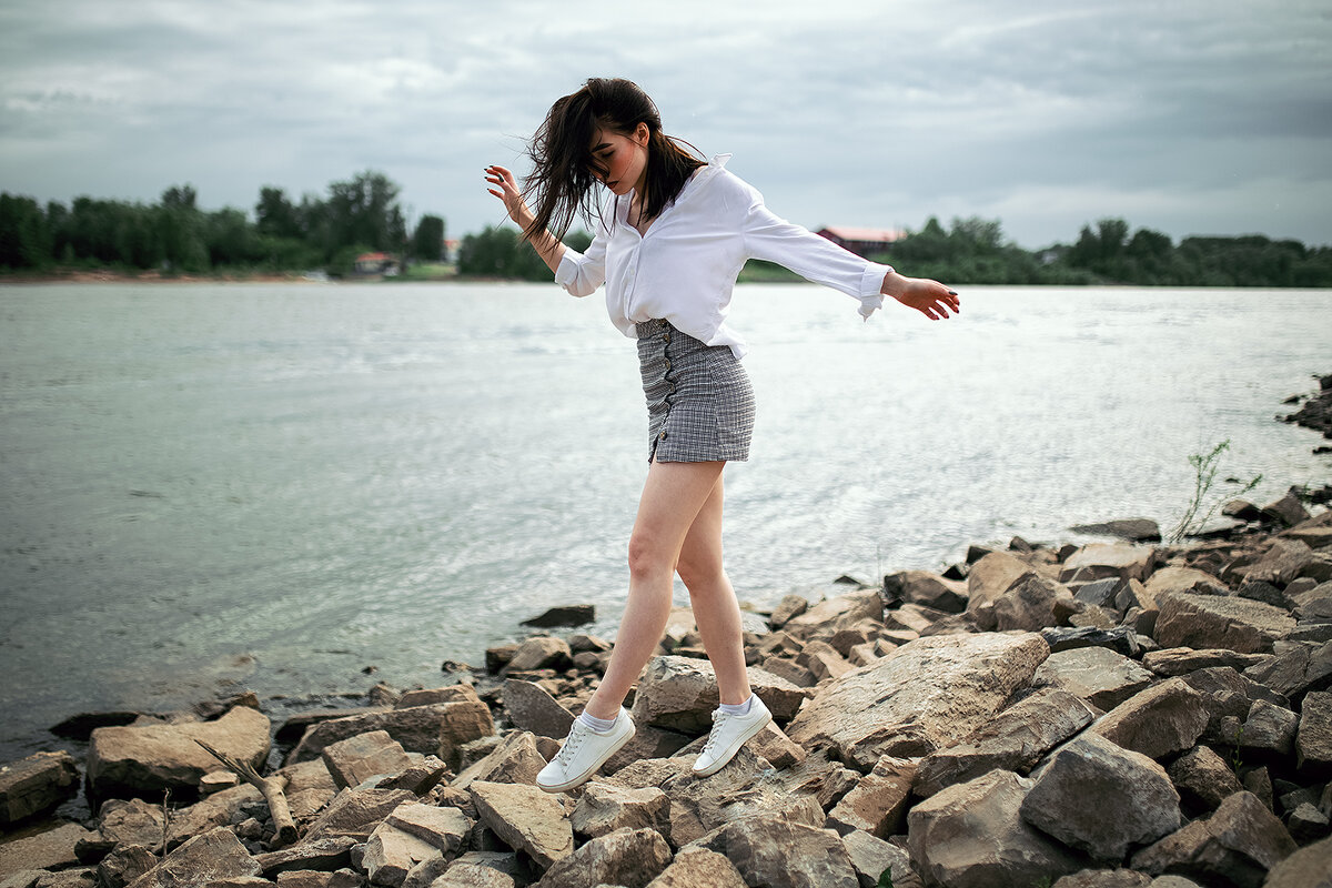 Девушка в белой рубашке ходит по камням на берегу реки во время дождя - Lenar Abdrakhmanov