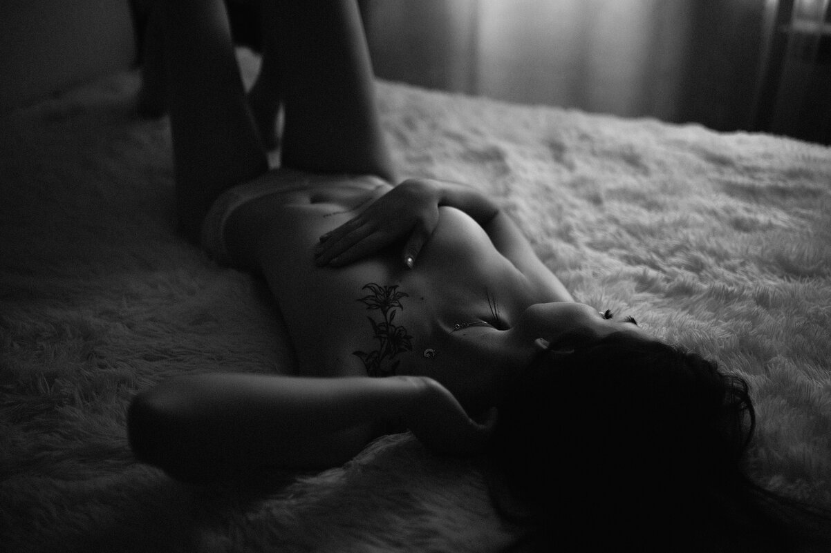Девушка в белье прикрывает грудь рукой, лежа на большой кровати - Lenar Abdrakhmanov