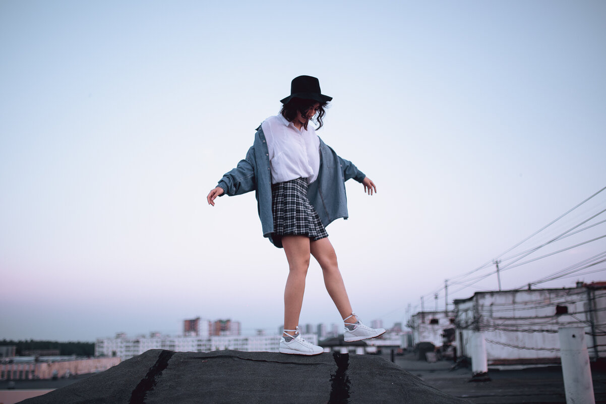 Девушка в шляпе белой рубашке и джинсовке гуляет по крыше дома на закате - Lenar Abdrakhmanov