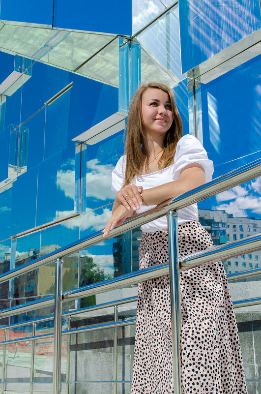 Красивая девушка стоит у стеклянного здания - Максим Мокрецов