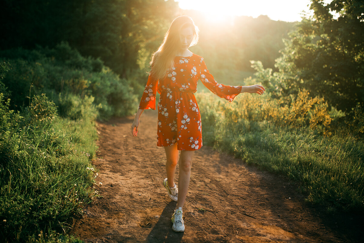 Девушка в красном платье и белых кедах гуляет по лесу во время рассвета - Lenar Abdrakhmanov
