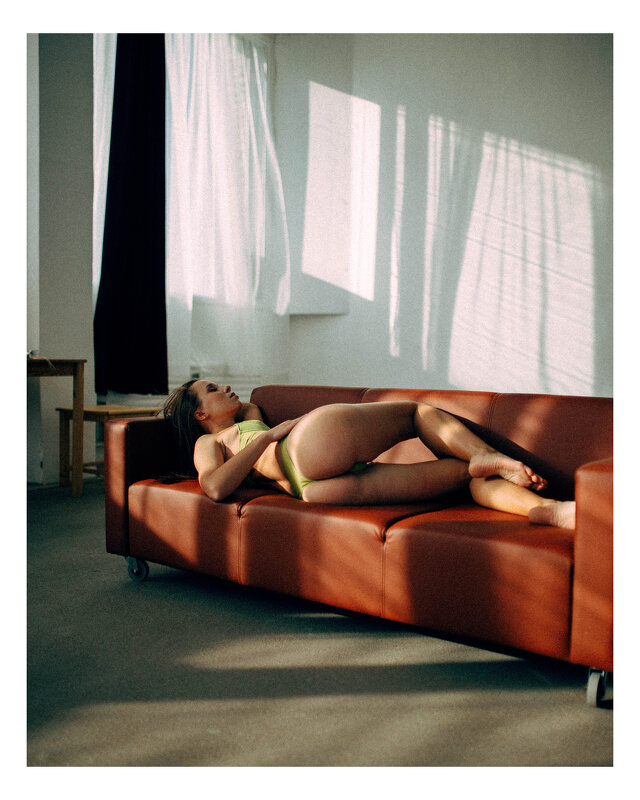 Девушка в нижнем белье лежит на красном диване в солнечной студии - Lenar Abdrakhmanov