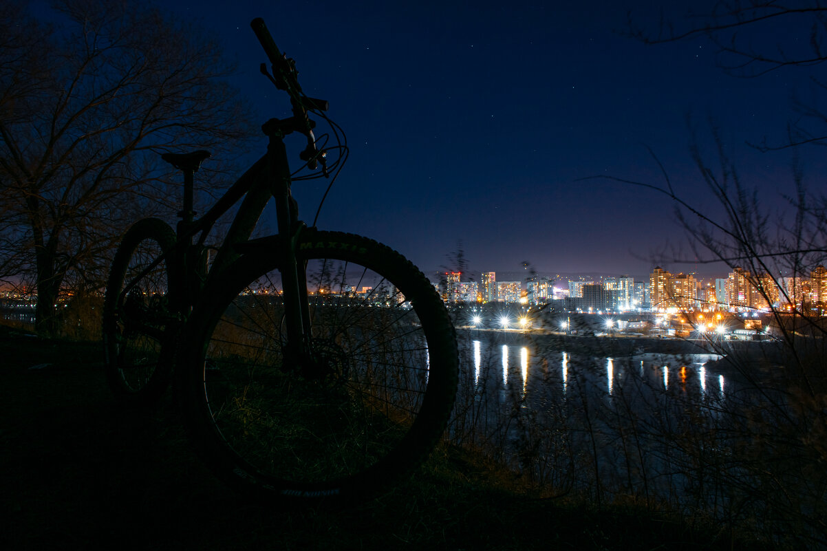 Велосипед на фоне городских огней - Николай Чекалин