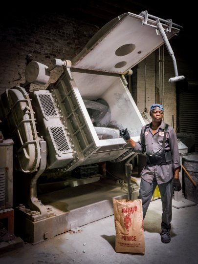 Этот сотрудник работает на производстве в течение 47 лет. Смеситель позади него обрабатывает пастель и уголь.
