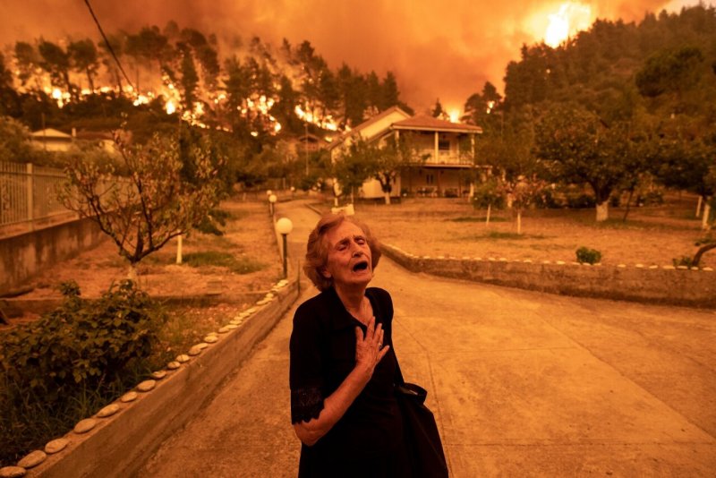 Победитель, Европа, 2022. Лесной пожар приближается к деревне на острове Эвбея, Греция, 8 августа 2021 года. Автор Константинос Цакалидис.