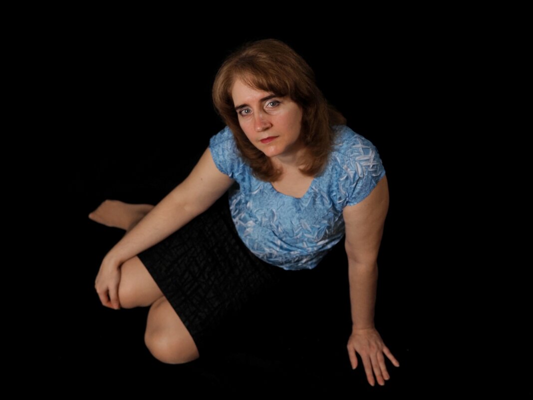 Женский портрет сидя на чёрном фоне - photo Bo